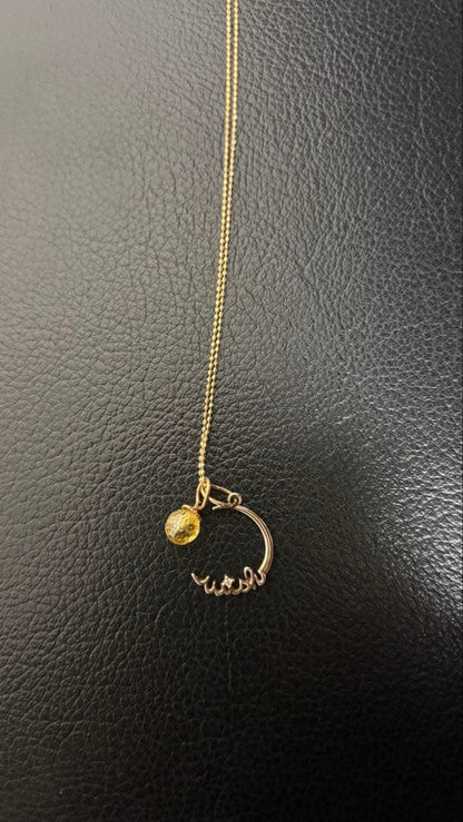 Agete gold pendant top with crescent moon and star motif on a white background