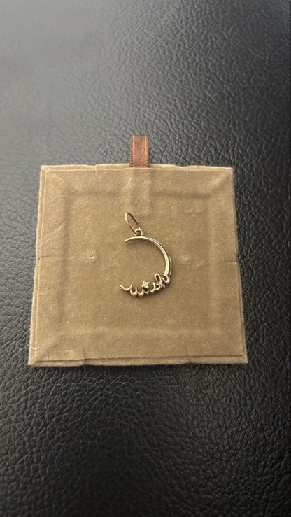 Agete gold pendant top with crescent moon and star motif on a white background