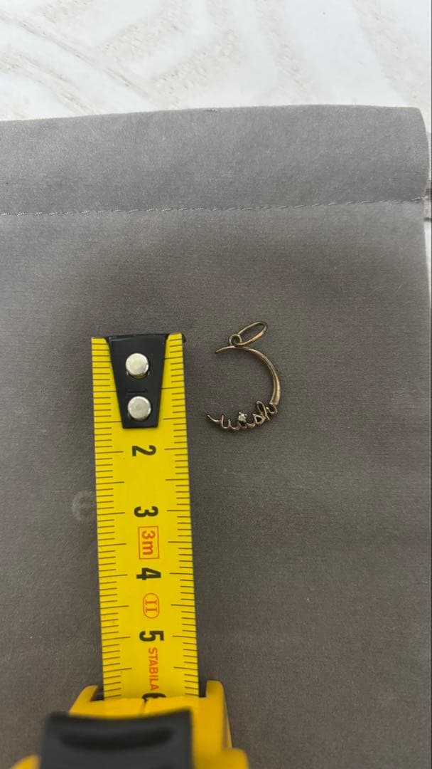 Agete gold pendant top with crescent moon and star motif on a white background