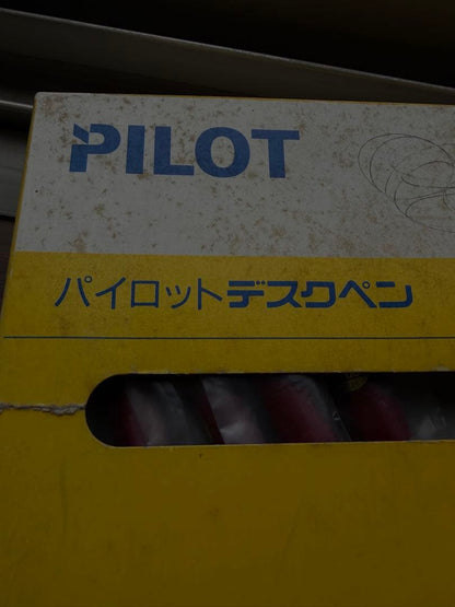 New Pilot desk pen next to a worn and dirty box with torn edges