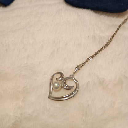 MIKIMOTO heart-shaped silver necklace adorned with a pearl and includes a dedicated pouch