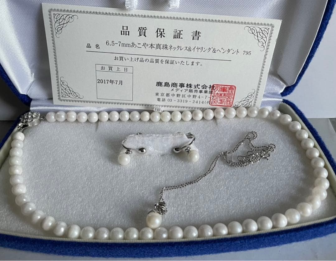 Akoya pearl necklace, earrings, and pendant set with 7mm pearls and silver clasp on white background