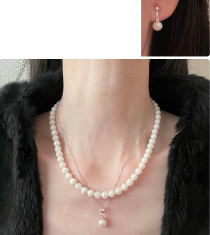 Akoya pearl necklace, earrings, and pendant set with 7mm pearls and silver clasp on white background