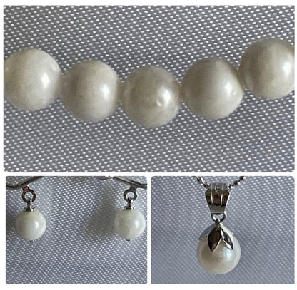 Akoya pearl necklace, earrings, and pendant set with 7mm pearls and silver clasp on white background