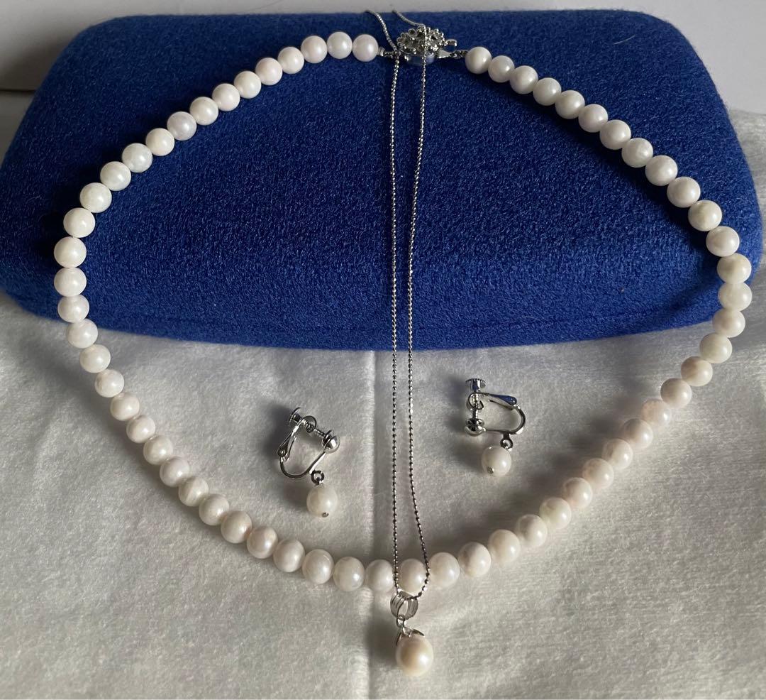 Akoya pearl necklace, earrings, and pendant set with 7mm pearls and silver clasp on white background