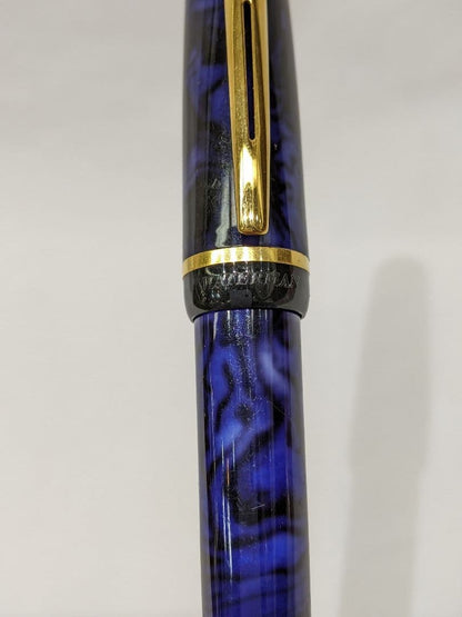 WATERMAN Philéas fountain pen with blue marble finish and gold trim displayed next to its dedicated case