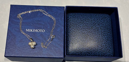 Mikimoto pearl necklace with a pendant featuring three pearls in a row, displayed in a dedicated box
