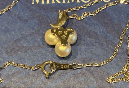 Mikimoto pearl necklace with a pendant featuring three pearls in a row, displayed in a dedicated box