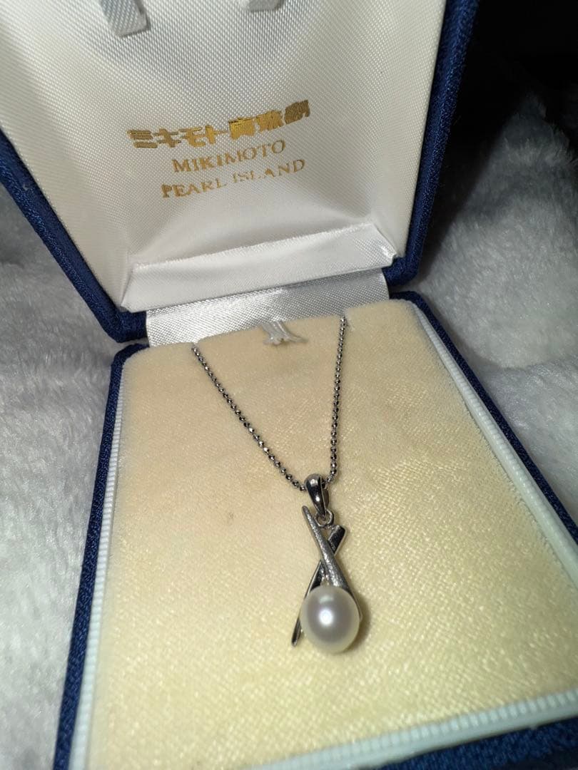 Tasaki silver necklace with a pearl pendant and lobster clasp displayed with a dedicated case