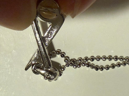 Tasaki silver necklace with a pearl pendant and lobster clasp displayed with a dedicated case
