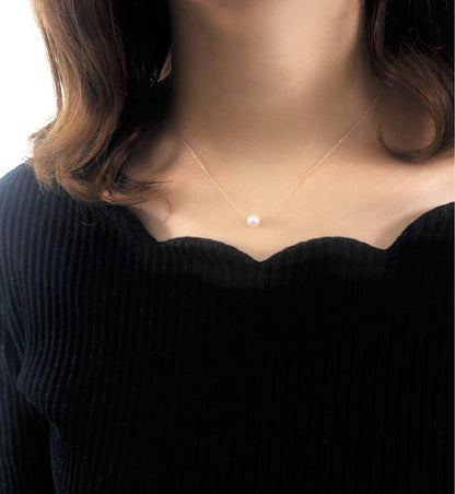 Akoya pearl necklace with 6.5mm pearls, 18K gold chain, and a birthstone pendant on a white background