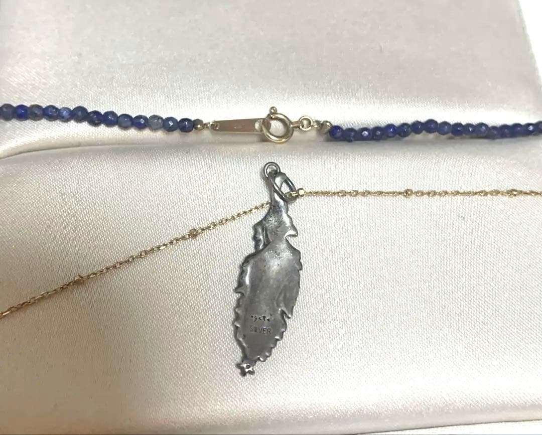 Agete necklace featuring navy lapis lazuli stone with 10 karat gold chain and silver feather charm set