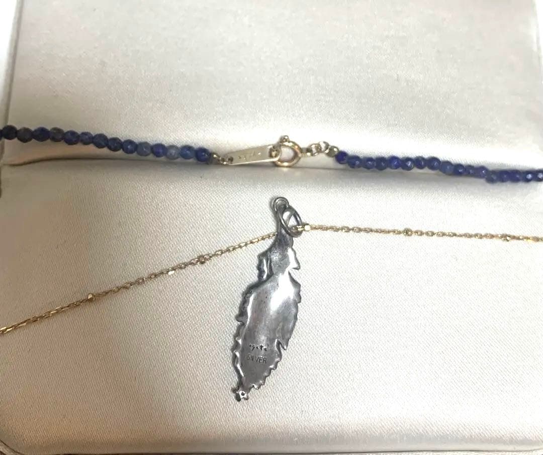 Agete necklace featuring navy lapis lazuli stone with 10 karat gold chain and silver feather charm set