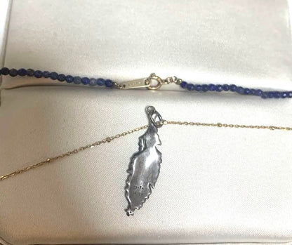 Agete necklace featuring navy lapis lazuli stone with 10 karat gold chain and silver feather charm set