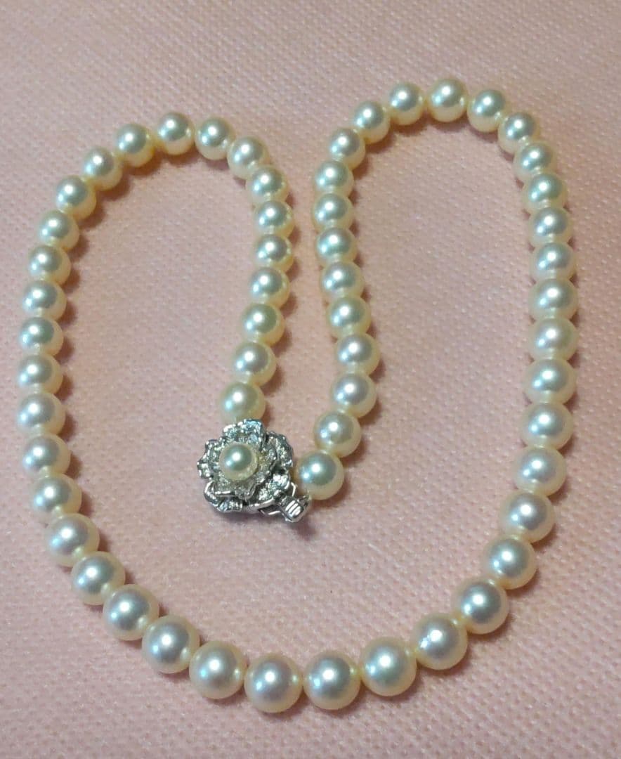 Tasaki Akoya Pearl 7.0mm necklace and matching 7.0mm pearl earrings on a white background
