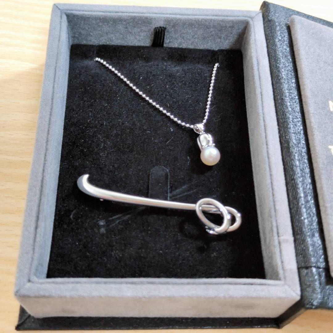 Tasaki silver necklace with 7.5mm pearl and matching brooch on white background