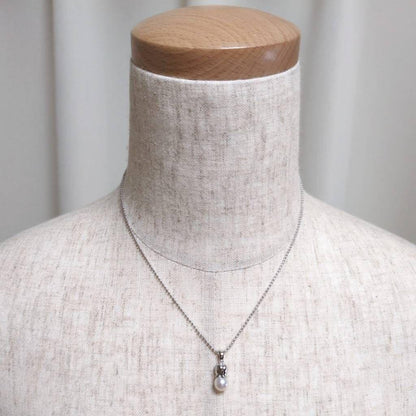 Tasaki silver necklace with 7.5mm pearl and matching brooch on white background