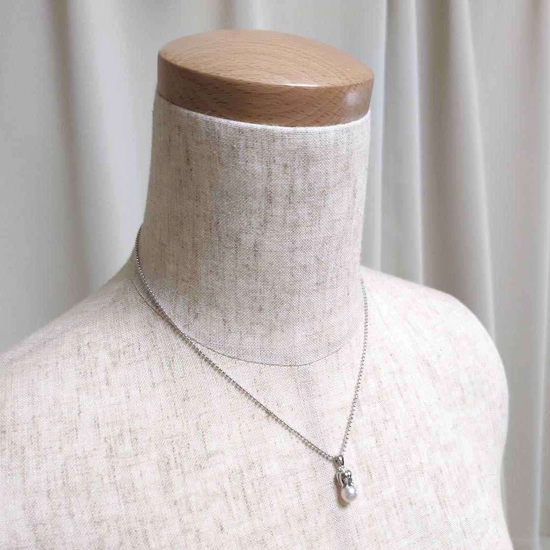 Tasaki silver necklace with 7.5mm pearl and matching brooch on white background