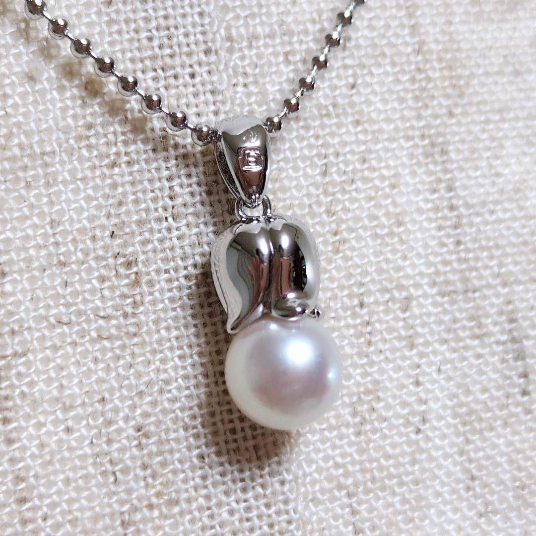Tasaki silver necklace with 7.5mm pearl and matching brooch on white background
