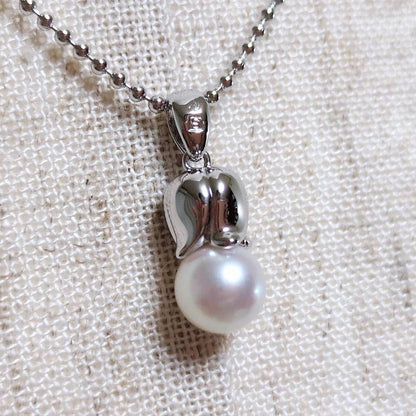 Tasaki silver necklace with 7.5mm pearl and matching brooch on white background