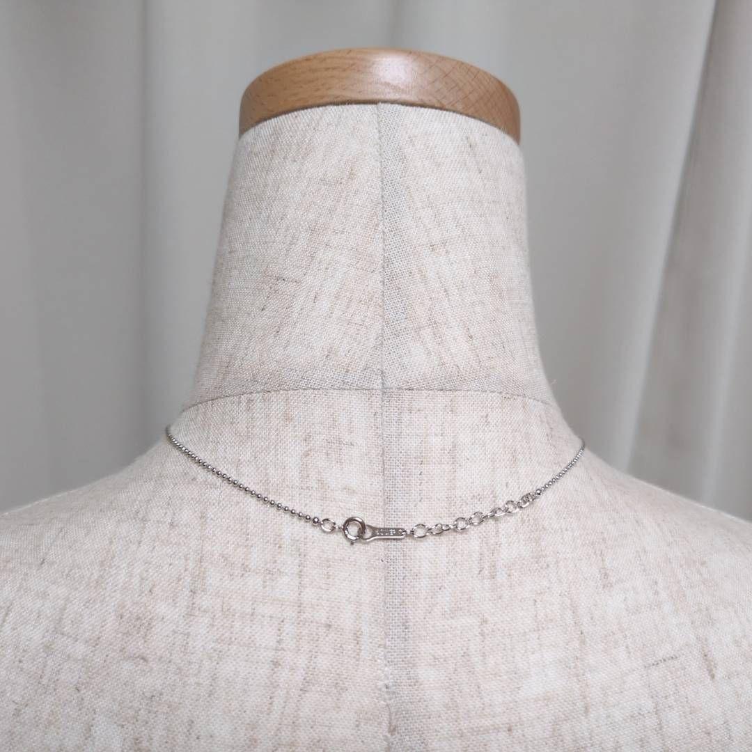 Tasaki silver necklace with 7.5mm pearl and matching brooch on white background