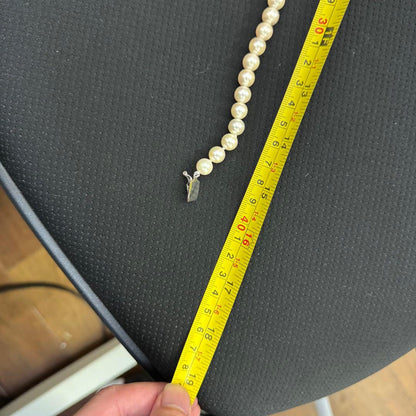 Short Akoya pearl necklace with 8mm white pearls on a white background