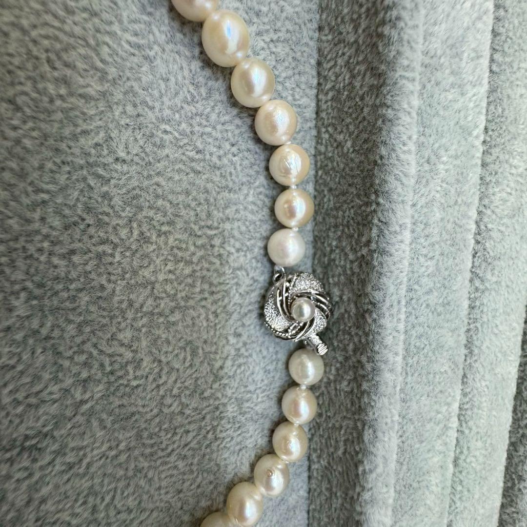 Short Akoya pearl necklace with 8mm white pearls on a white background