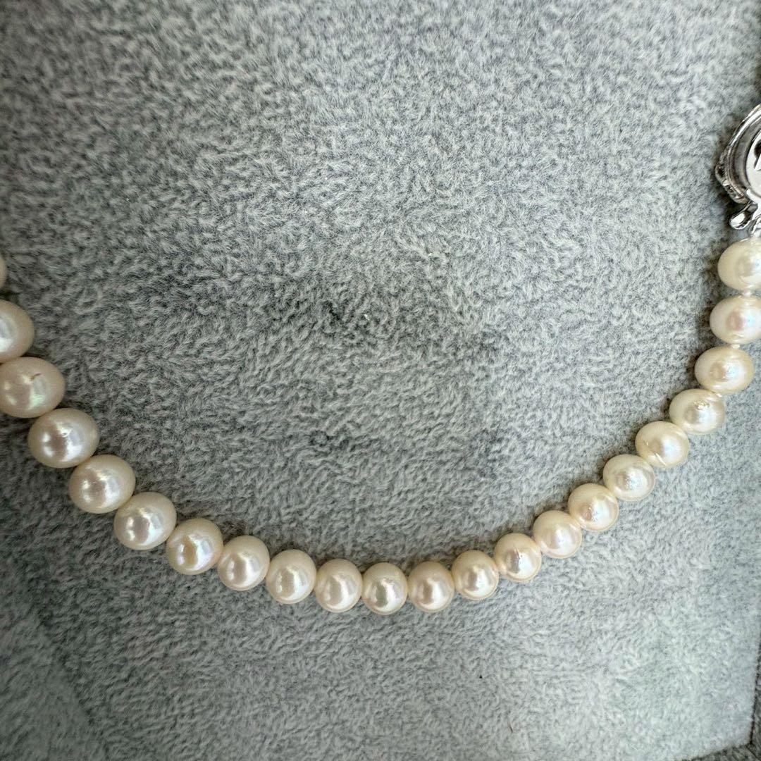 Short Akoya pearl necklace with 8mm white pearls on a white background