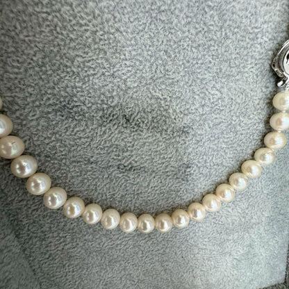 Short Akoya pearl necklace with 8mm white pearls on a white background