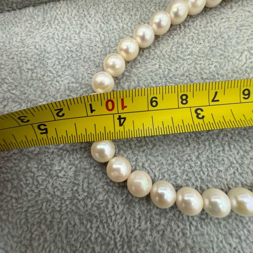 Short Akoya pearl necklace with 8mm white pearls on a white background