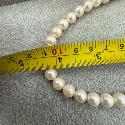Short Akoya pearl necklace with 8mm white pearls on a white background