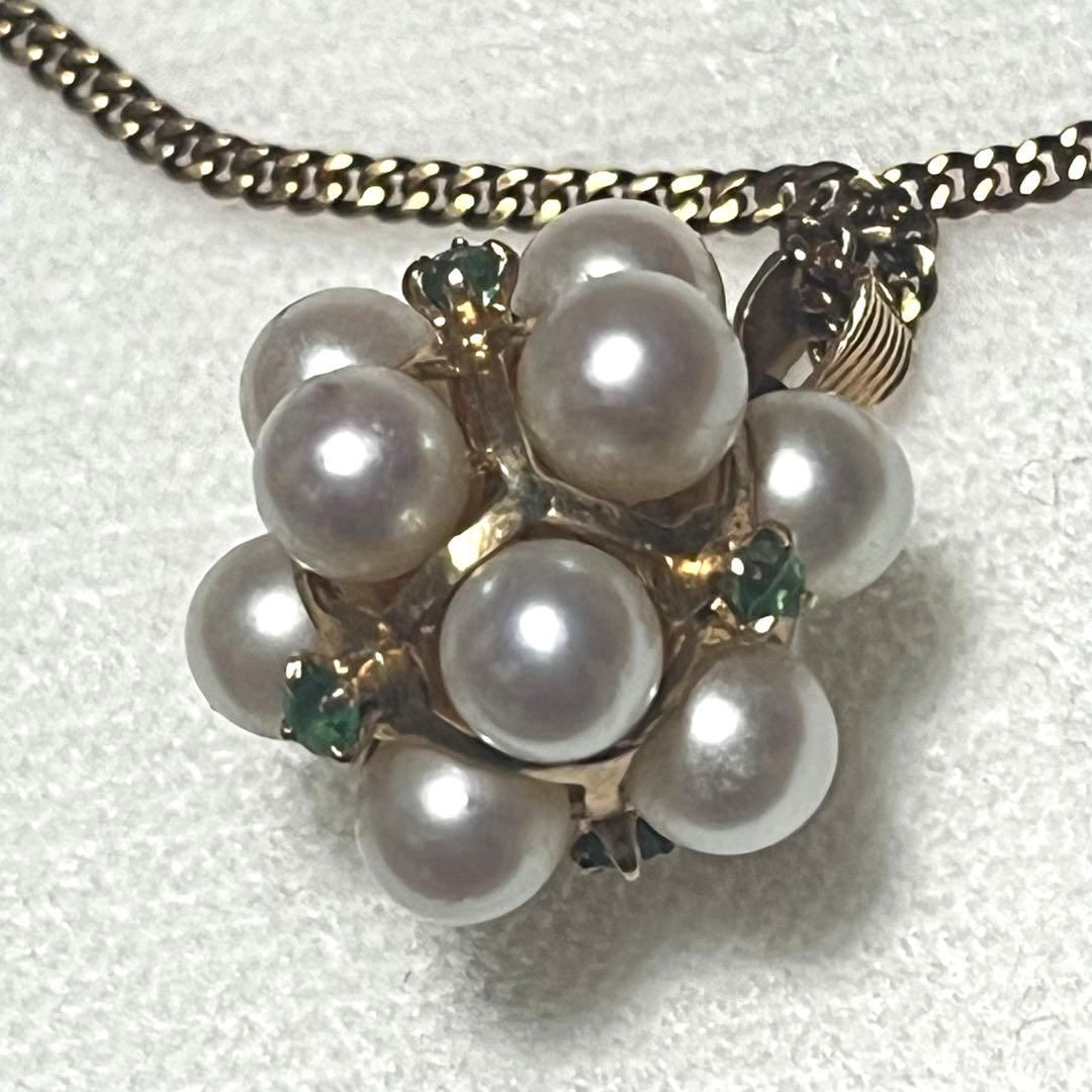 Akoya pearl necklace top with 12 round pearls and emerald-like green stones set in 14K gold weighing 3.7 grams