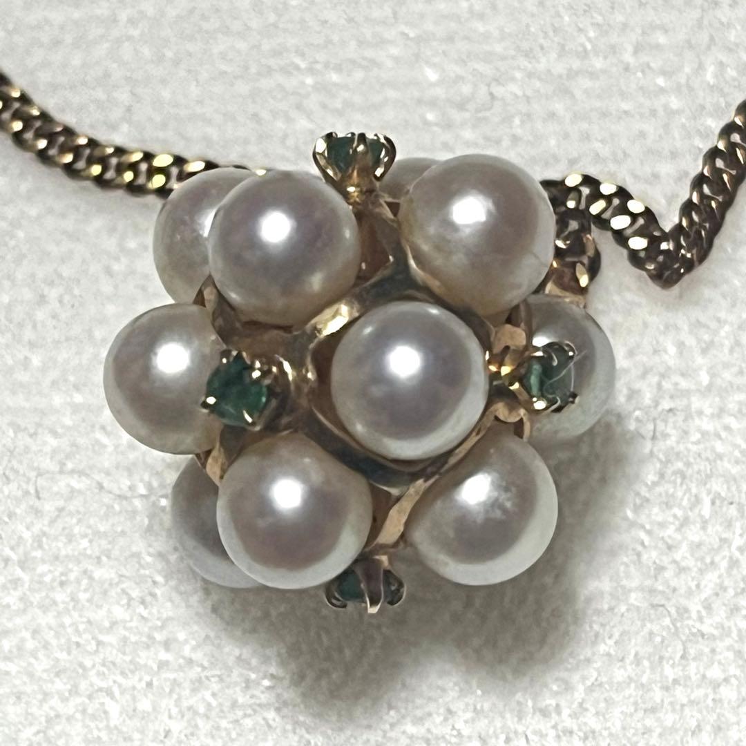 Akoya pearl necklace top with 12 round pearls and emerald-like green stones set in 14K gold weighing 3.7 grams