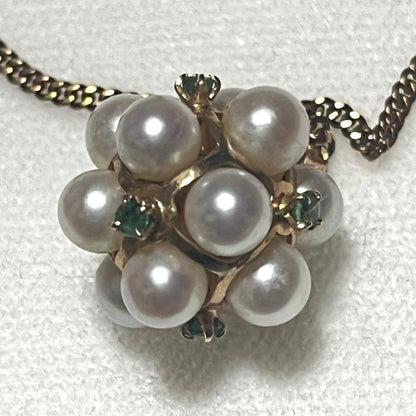 Akoya pearl necklace top with 12 round pearls and emerald-like green stones set in 14K gold weighing 3.7 grams