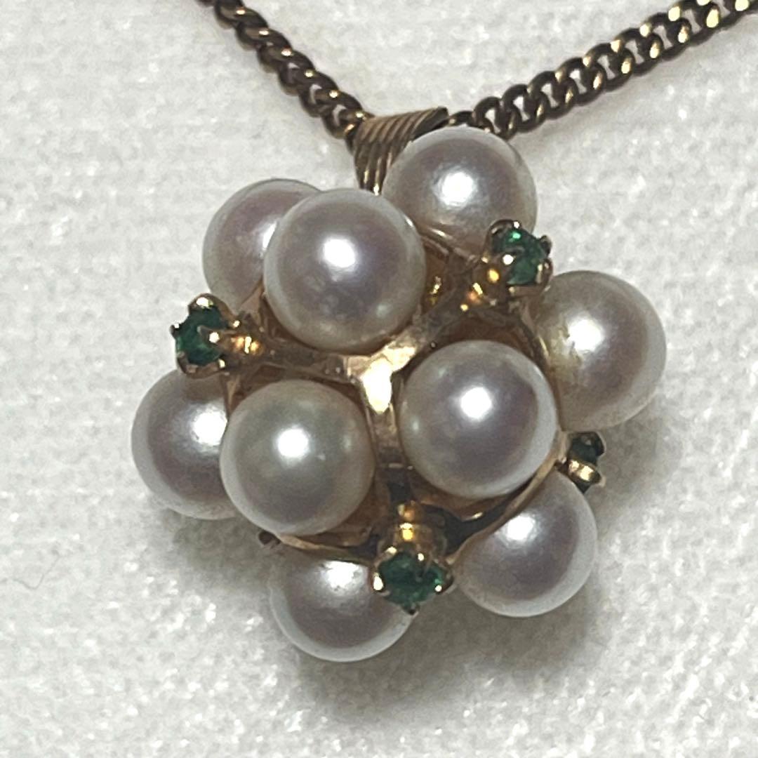 Akoya pearl necklace top with 12 round pearls and emerald-like green stones set in 14K gold weighing 3.7 grams