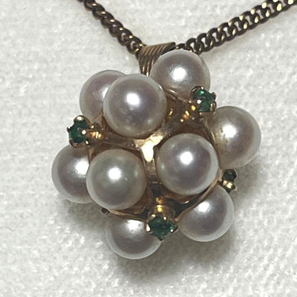 Akoya pearl necklace top with 12 round pearls and emerald-like green stones set in 14K gold weighing 3.7 grams