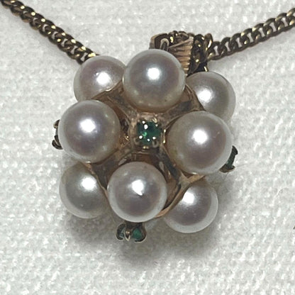 Akoya pearl necklace top with 12 round pearls and emerald-like green stones set in 14K gold weighing 3.7 grams