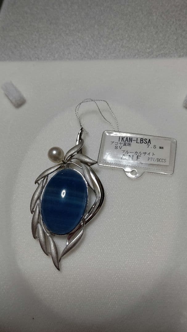Brooch and pendant set with 7.5mm Akoya pearl, blue calcite, silver frame on white background