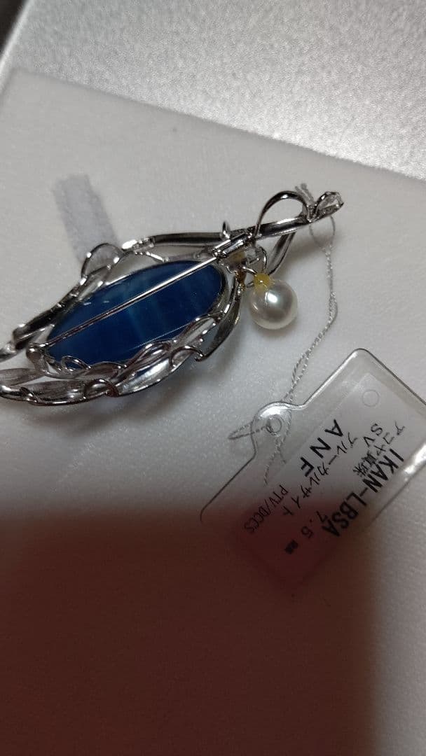 Brooch and pendant set with 7.5mm Akoya pearl, blue calcite, silver frame on white background