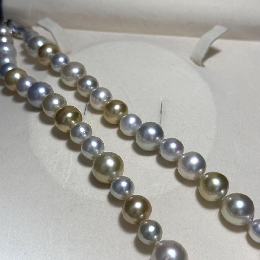 White butterfly pearl multi-color necklace with pearls sized 9.3-13.5 mm and silver clasp on display