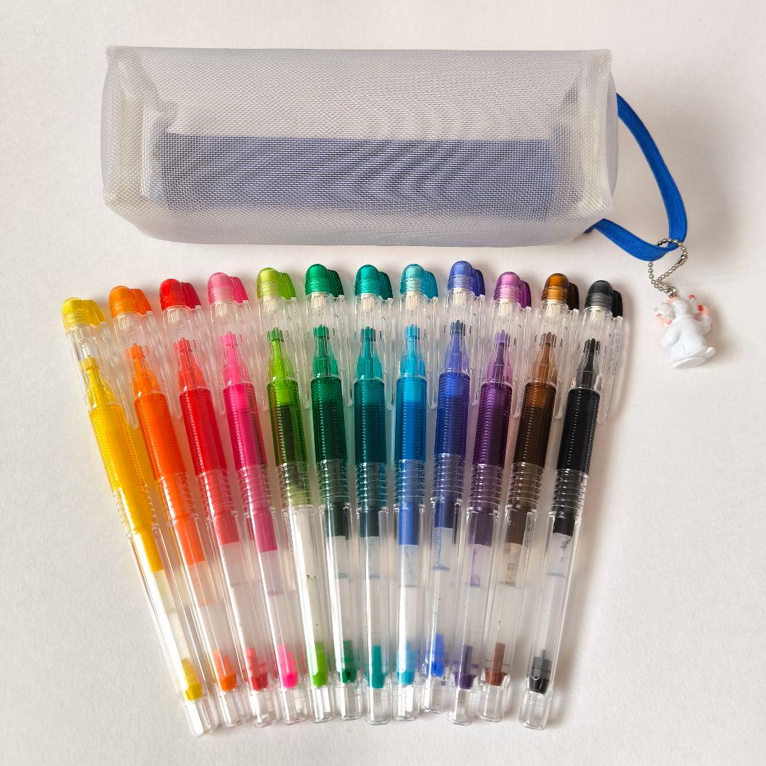 Pilot D-ink pen case set with 12 colorful ballpoint pens and a small mascot figure in a plastic case