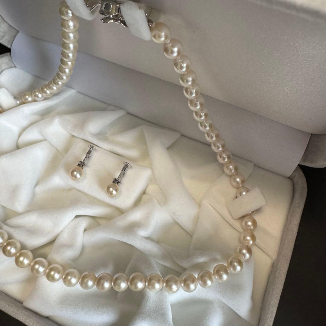 Akoya pearl necklace and earring set with white pearls and silver fittings displayed with black box