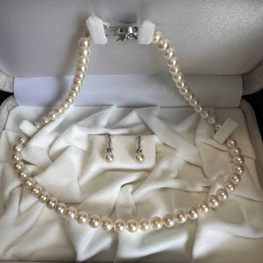 Akoya pearl necklace and earring set with white pearls and silver fittings displayed with black box