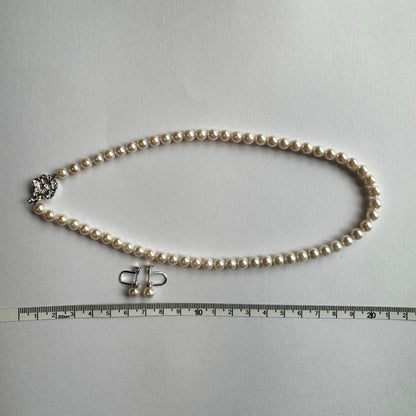 Akoya pearl necklace and earring set with white pearls and silver fittings displayed with black box