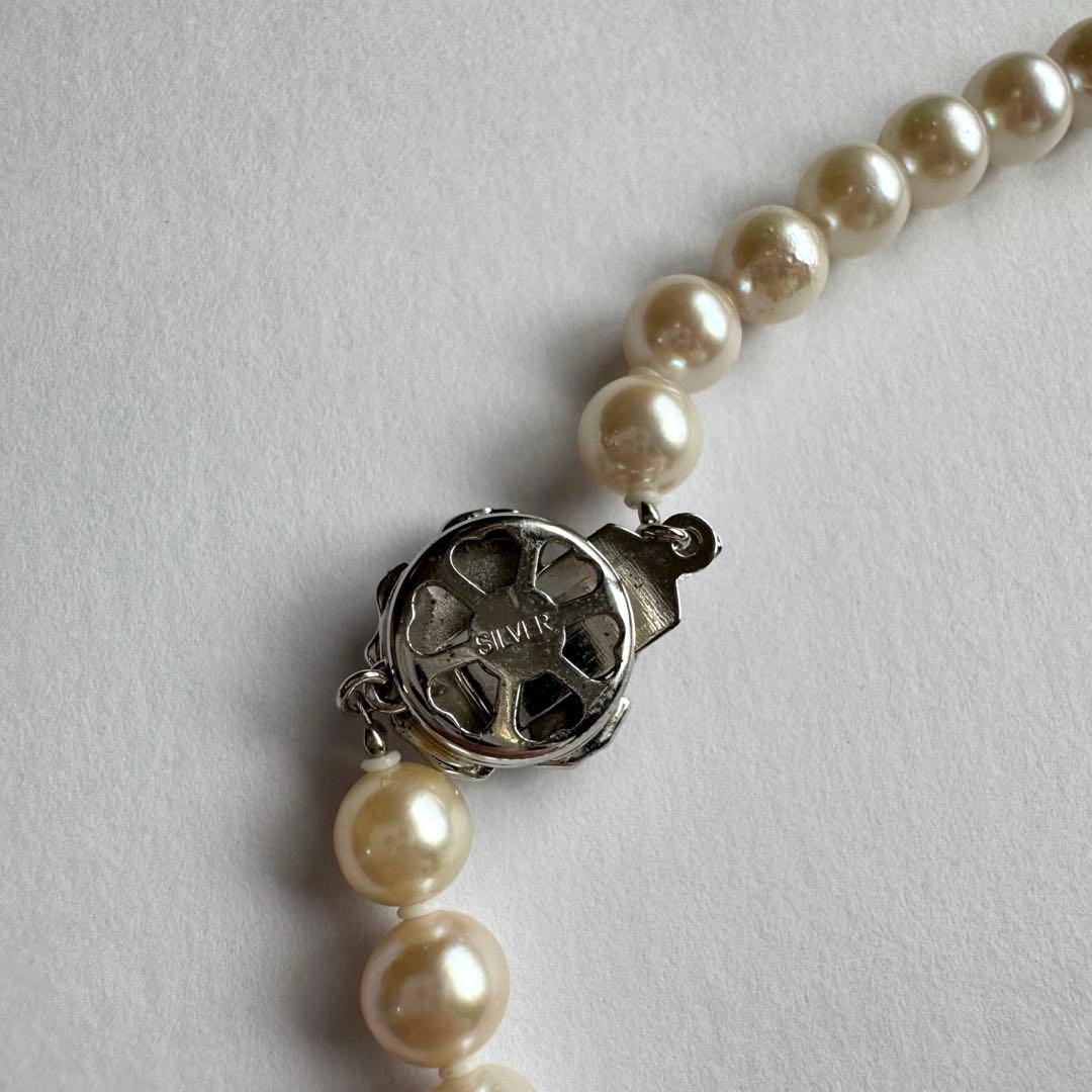 Akoya pearl necklace and earring set with white pearls and silver fittings displayed with black box