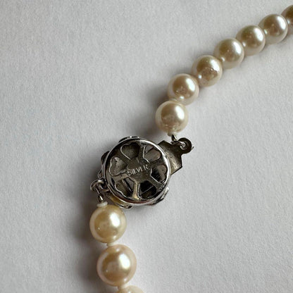 Akoya pearl necklace and earring set with white pearls and silver fittings displayed with black box