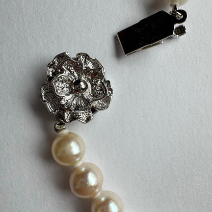 Akoya pearl necklace and earring set with white pearls and silver fittings displayed with black box