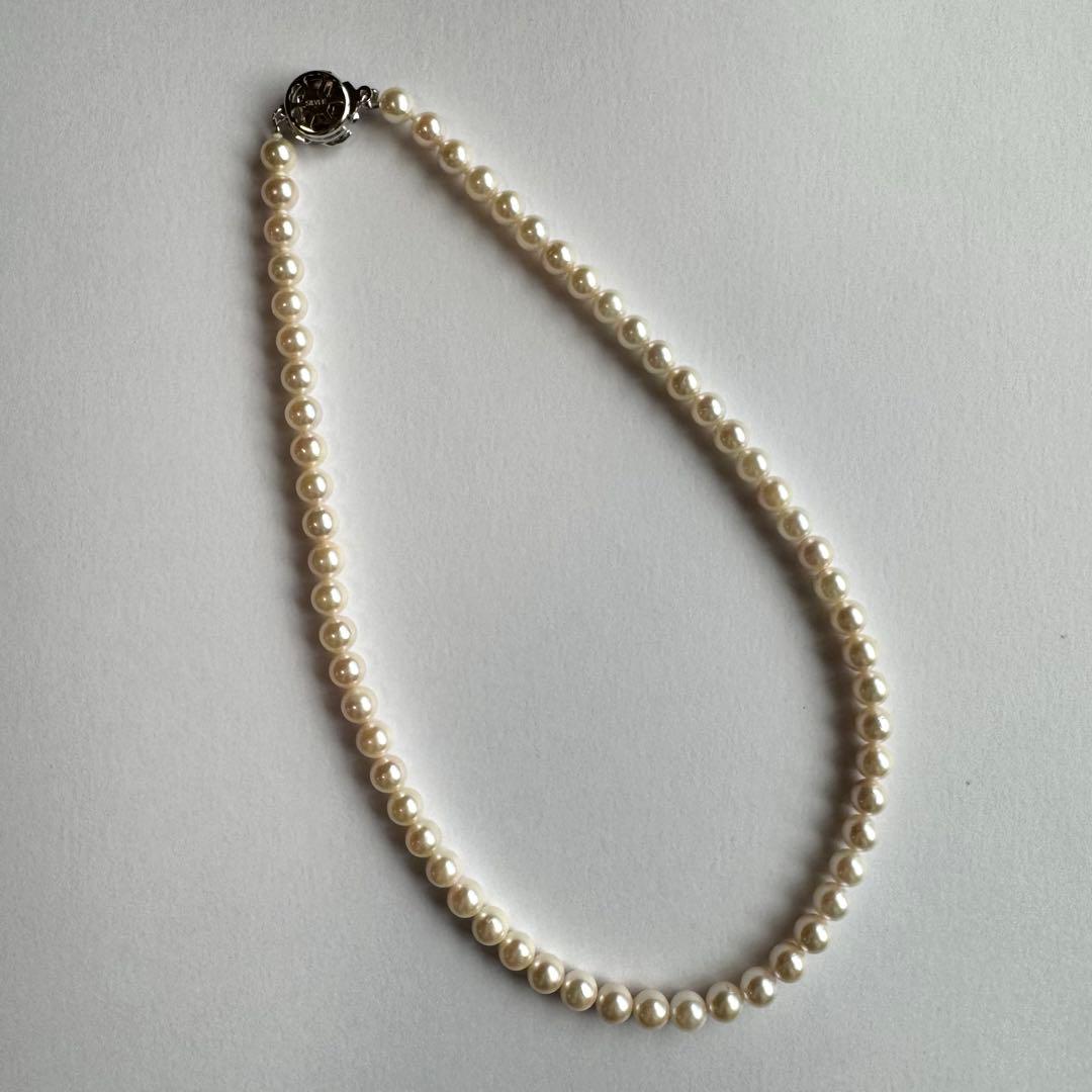 Akoya pearl necklace and earring set with white pearls and silver fittings displayed with black box