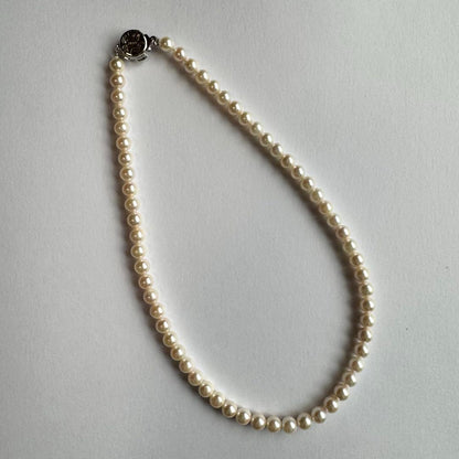 Akoya pearl necklace and earring set with white pearls and silver fittings displayed with black box