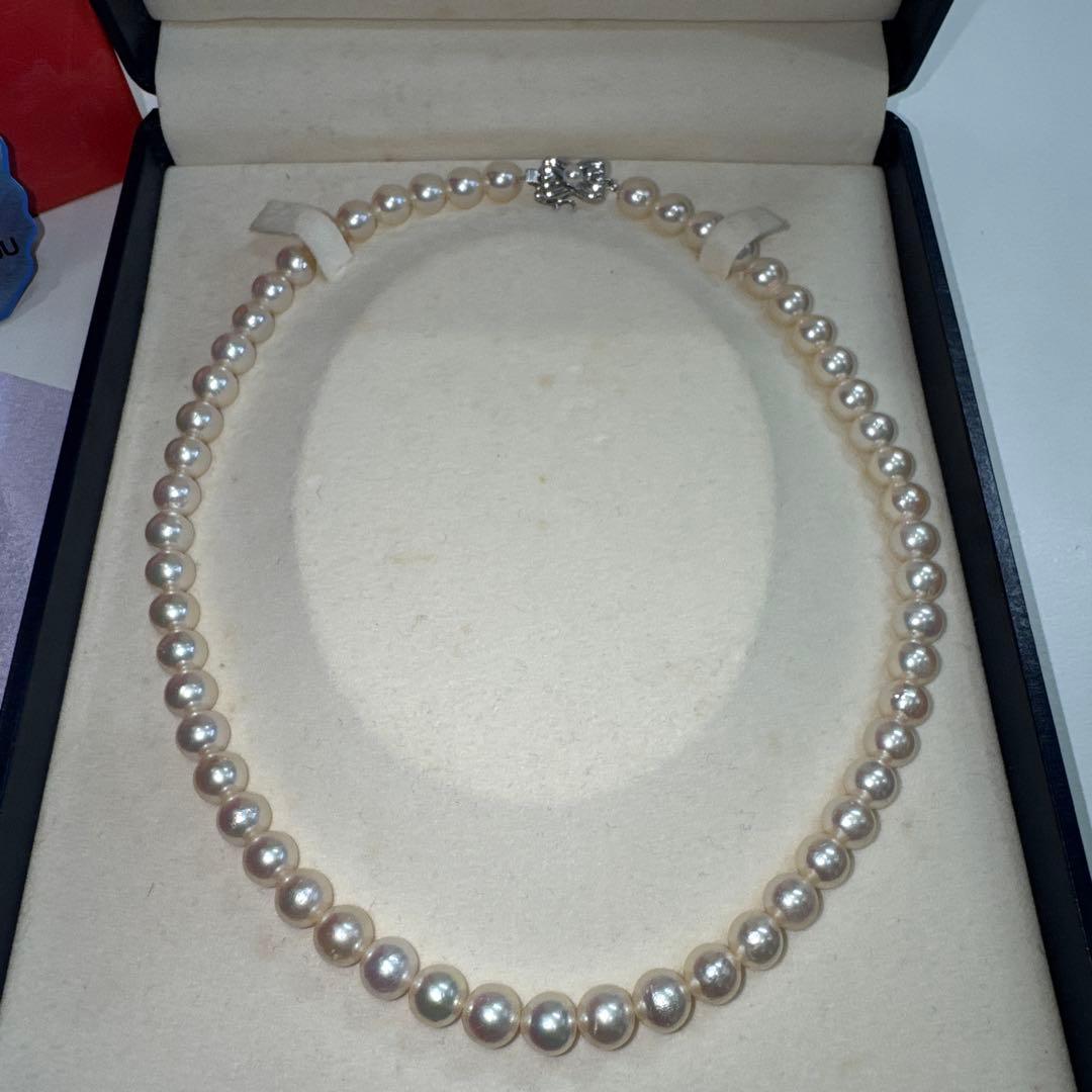 Tasaki pearl necklace with ribbon clasp measuring 43.5 centimeters displayed on white background